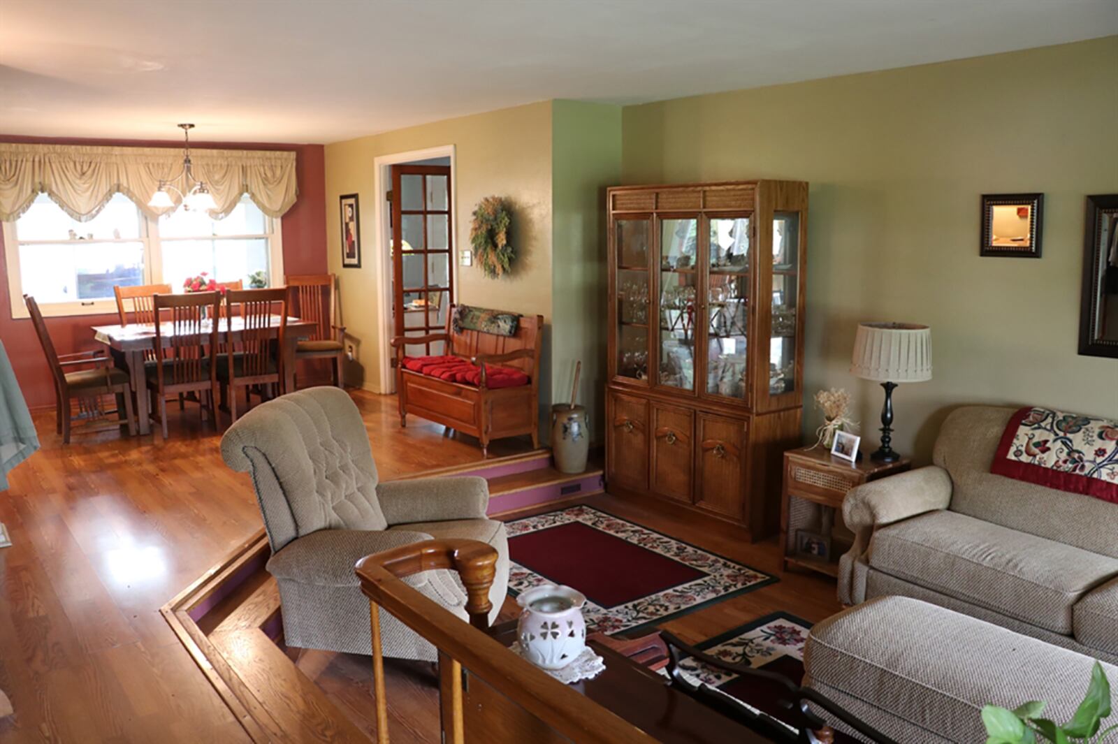 Formal entry is accessible from a covered front patio into a foyer hallway that is accented by a wooden banister and railing that offset the sunken living room. Two-steps down separates the living room from the dining area as the open space is filled with natural light from the front bay window and rear picture window. CONTRIBUTED PHOTO BY KATHY TYLER