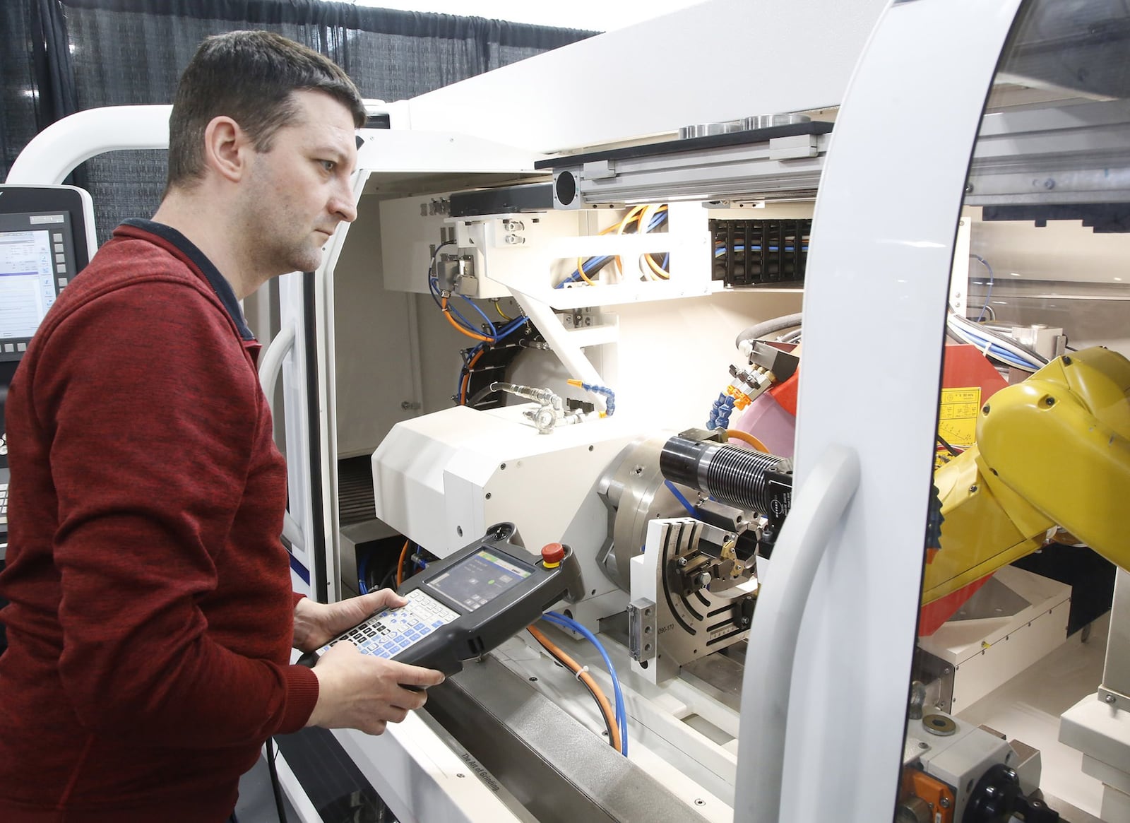 Andreas Steiner, automation engineer, prepares a universal grinder at United Grinding. United Grinding celebrated the opening of its new North American Headquarters in Miamisburg on April 17, 2018. TY GREENLEES / STAFF