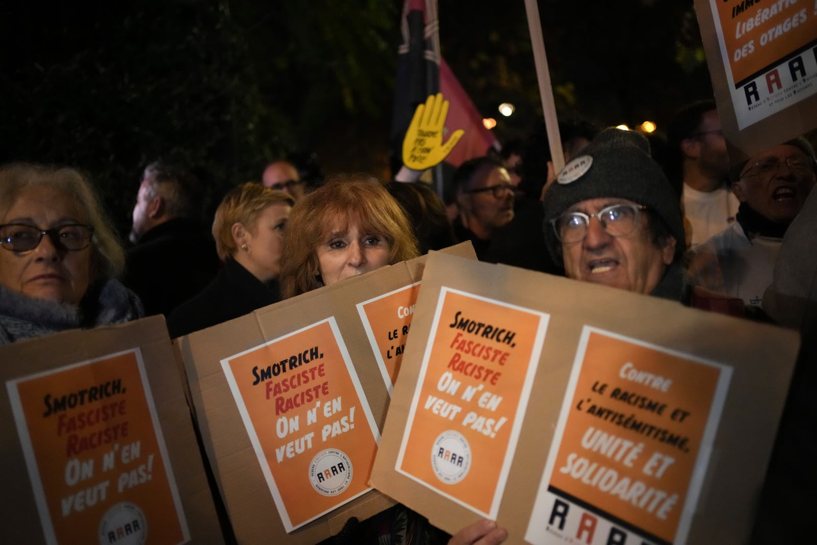 Protestors take part in a rally against the "Israel is Forever" gala organized by far-right Franco-Israeli figures, in Paris, Wednesday, Nov. 13, 2024, on the eve of the UEFA Nations League 2025 soccer match between France and Israel. Placards read " Smotrich, fascist, racist, we don't want him". (AP Photo/Christophe Ena)