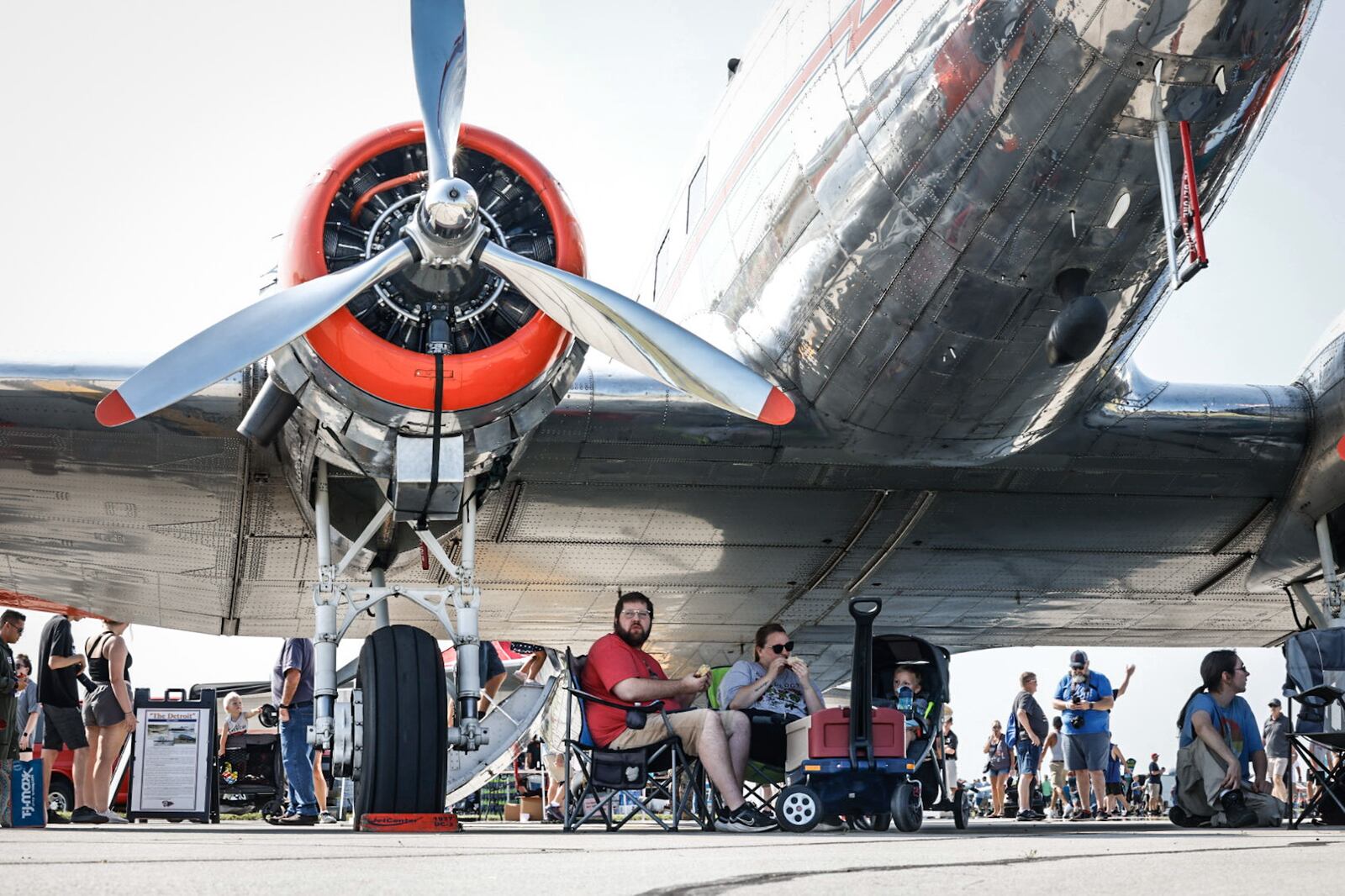 Andrew, Makayla and Luke Van Auken, from Indiana, find shade under a vintage American Airlines plane at the Dayton Air Show. Jim Noelker/Staff