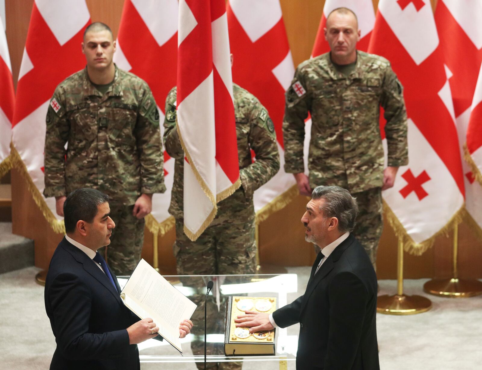 Georgian President-elect Mikheil Kavelashvili, right, takes the oath during his swearing-in ceremony at the Georgian parliament in Tbilisi, Georgia, Sunday, Dec. 29, 2024. (Irakli Gedenidze/Pool Photo via AP)