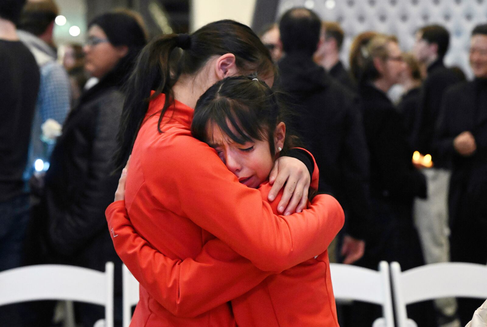 Young skaters Callan Rahardja, left, and Rivkah Chavez-Herrera comfort each other after a vigil held at the U.S. Olympic and Paralympic Museum in Colorado Springs, Colo., for the 28 skaters, family members and coaches who died in last weeks plane crash in Washington, D.C., Monday, Feb. 3, 2025. (Jerilee Bennett/The Gazette via AP)