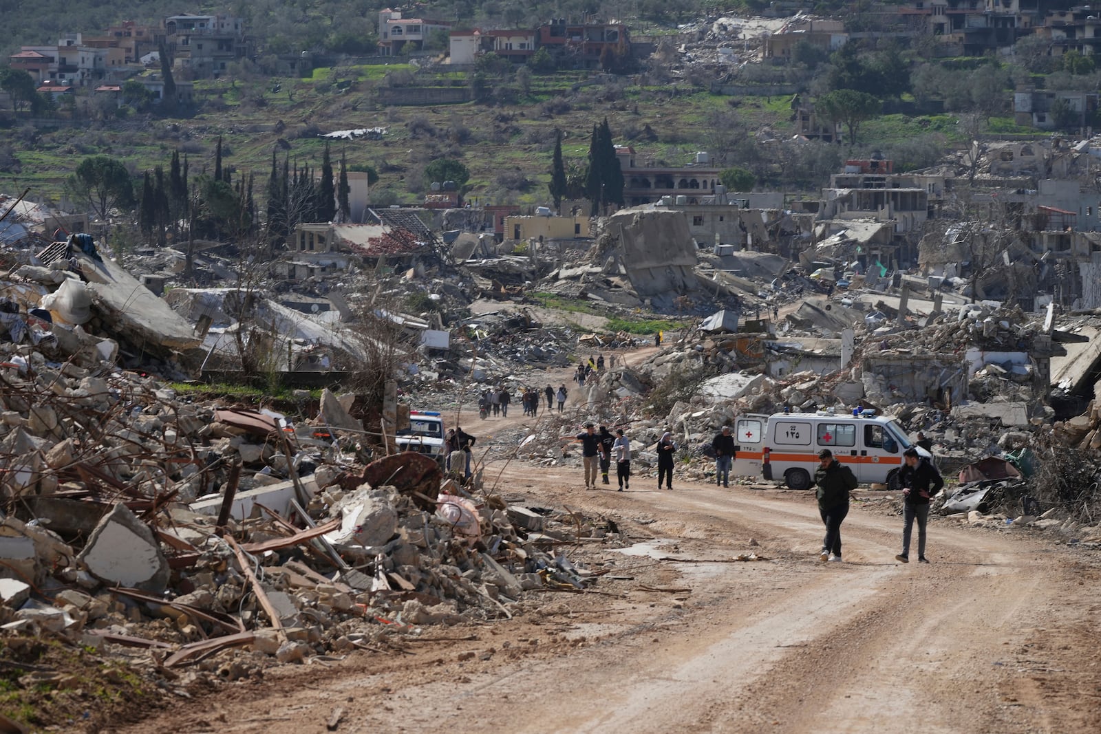 Lebanese citizens check the destruction in their village caused by the Israeli air and ground offensive, in the town of Kfar Kila, southern Lebanon, Tuesday, Feb. 18, 2025. (AP Photo/Hassan Ammar)