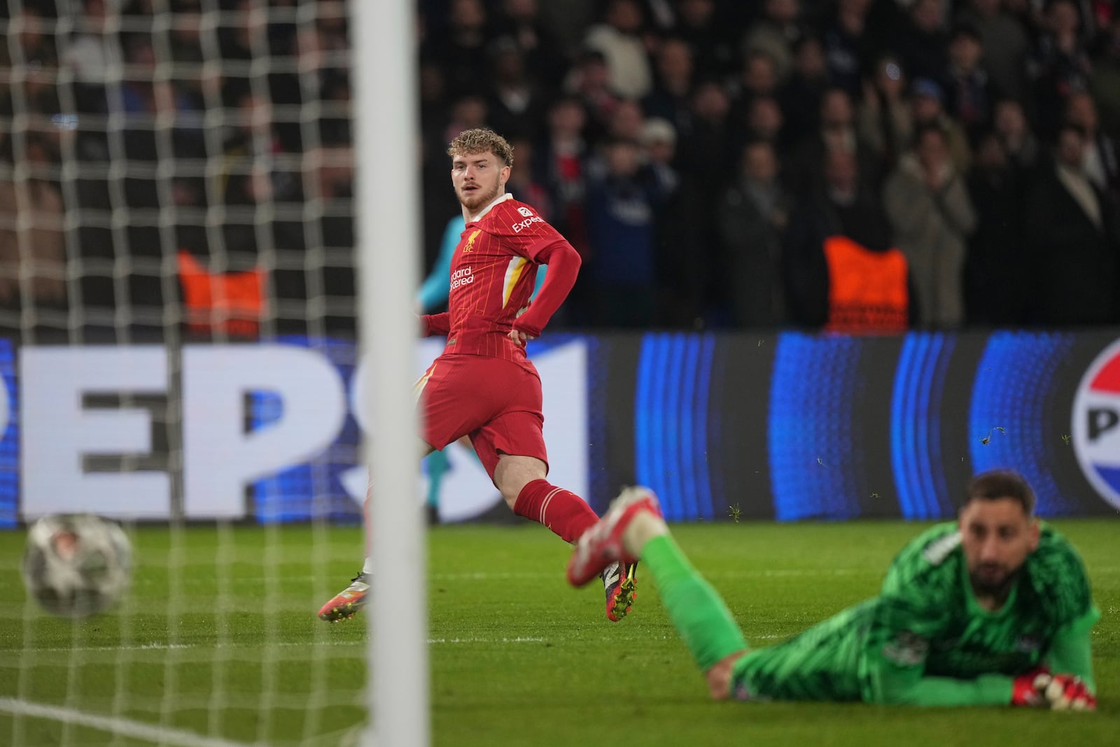 Liverpool's Harvey Elliott scores the opening goal past PSG's goalkeeper Gianluigi Donnarumma during the Champions League round of 16 first leg soccer match between Paris Saint-Germain and Liverpool at the Parc des Princes in Paris, Wednesday, March 5, 2025. (AP Photo/Aurelien Morissard)