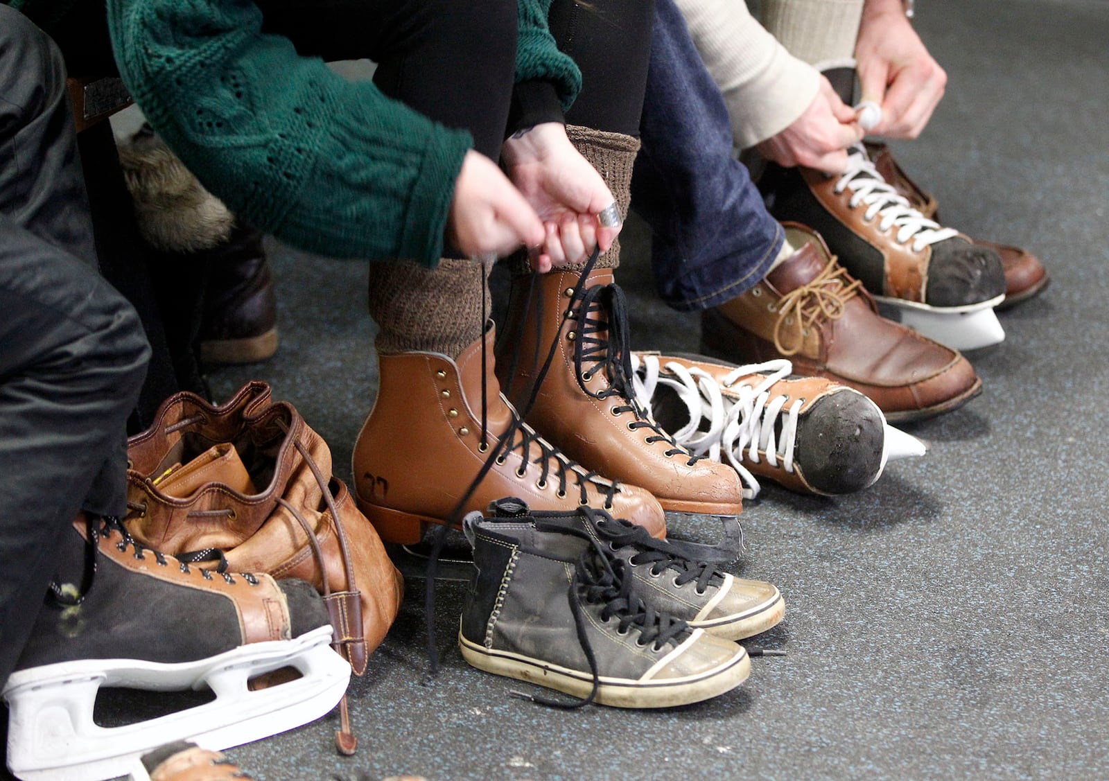 Skaters at the Kettering Rec Center lace up their rental skates before taking to the ice.  TY GREENLEES / STAFF