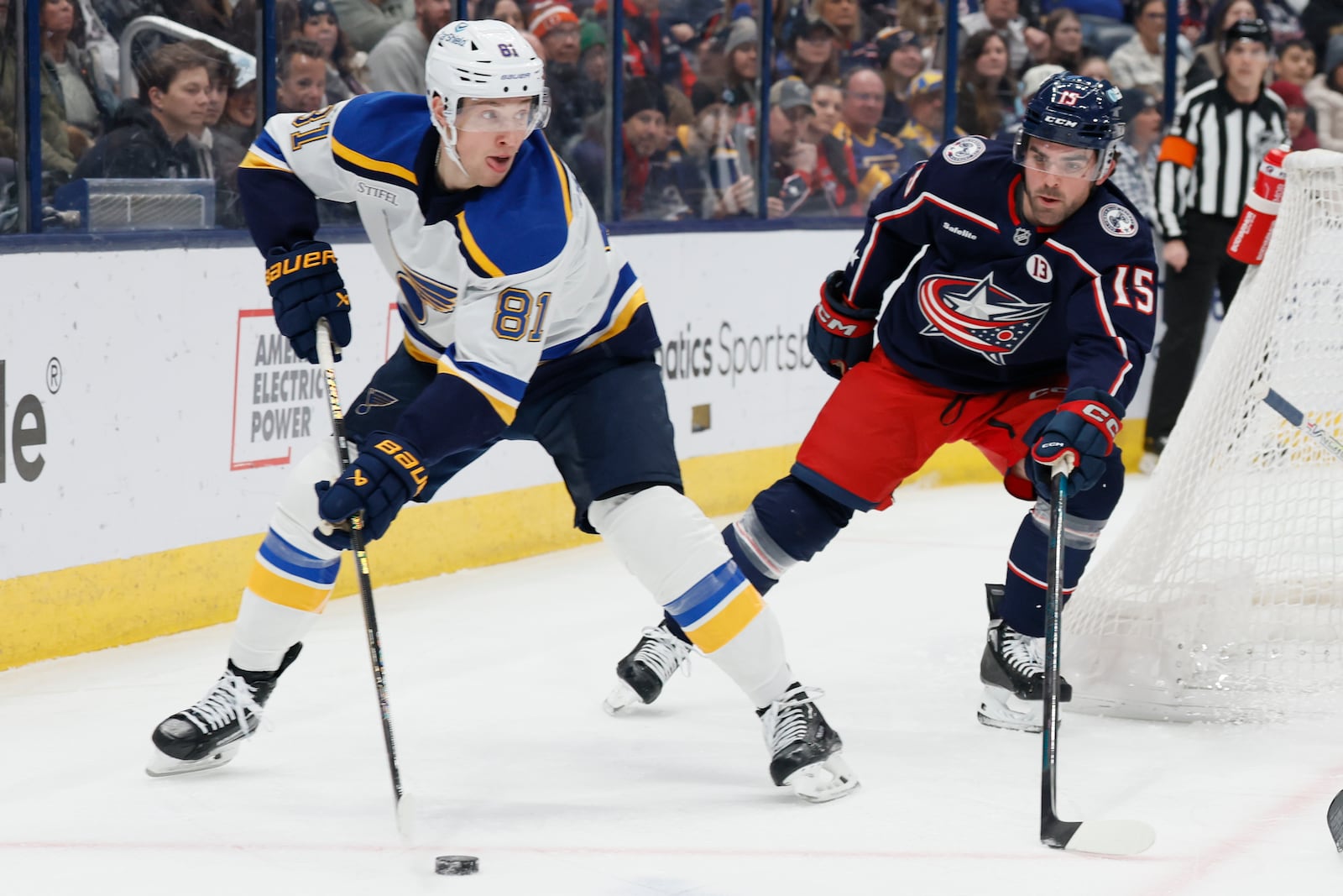 St. Louis Blues' Dylan Holloway, left, looks for an open pass as Columbus Blue Jackets' Dante Fabbro defends during the first period of an NHL hockey game Saturday, Jan. 4, 2025, in Columbus, Ohio. (AP Photo/Jay LaPrete)