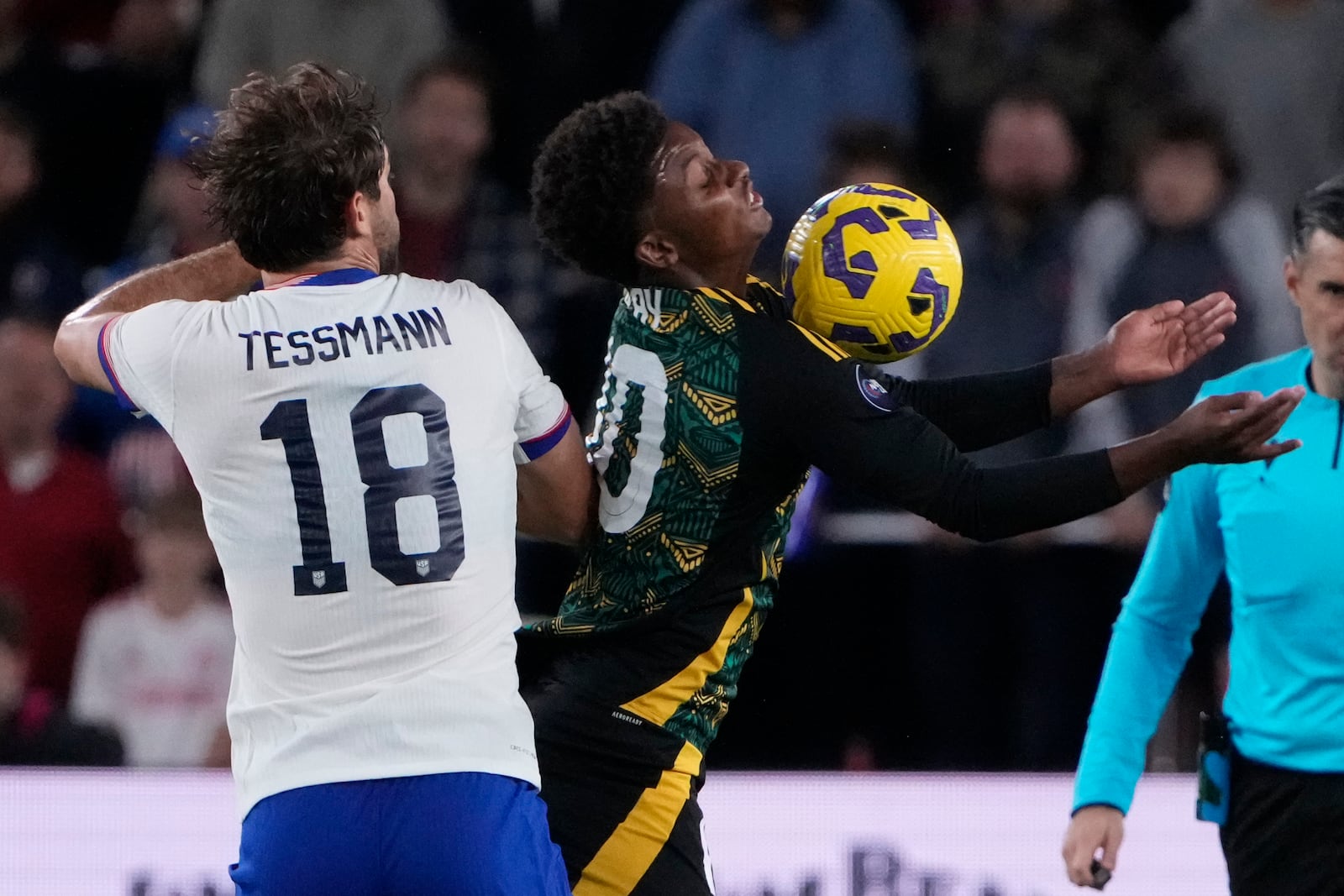 Jamaica's Demarai Gray and United States' Tanner Tessmann (18) battle for the ball during the first half in a CONCACAF Nations League quarterfinal second leg soccer match Monday, Nov. 18, 2024, in St. Louis. (AP Photo/Jeff Roberson)