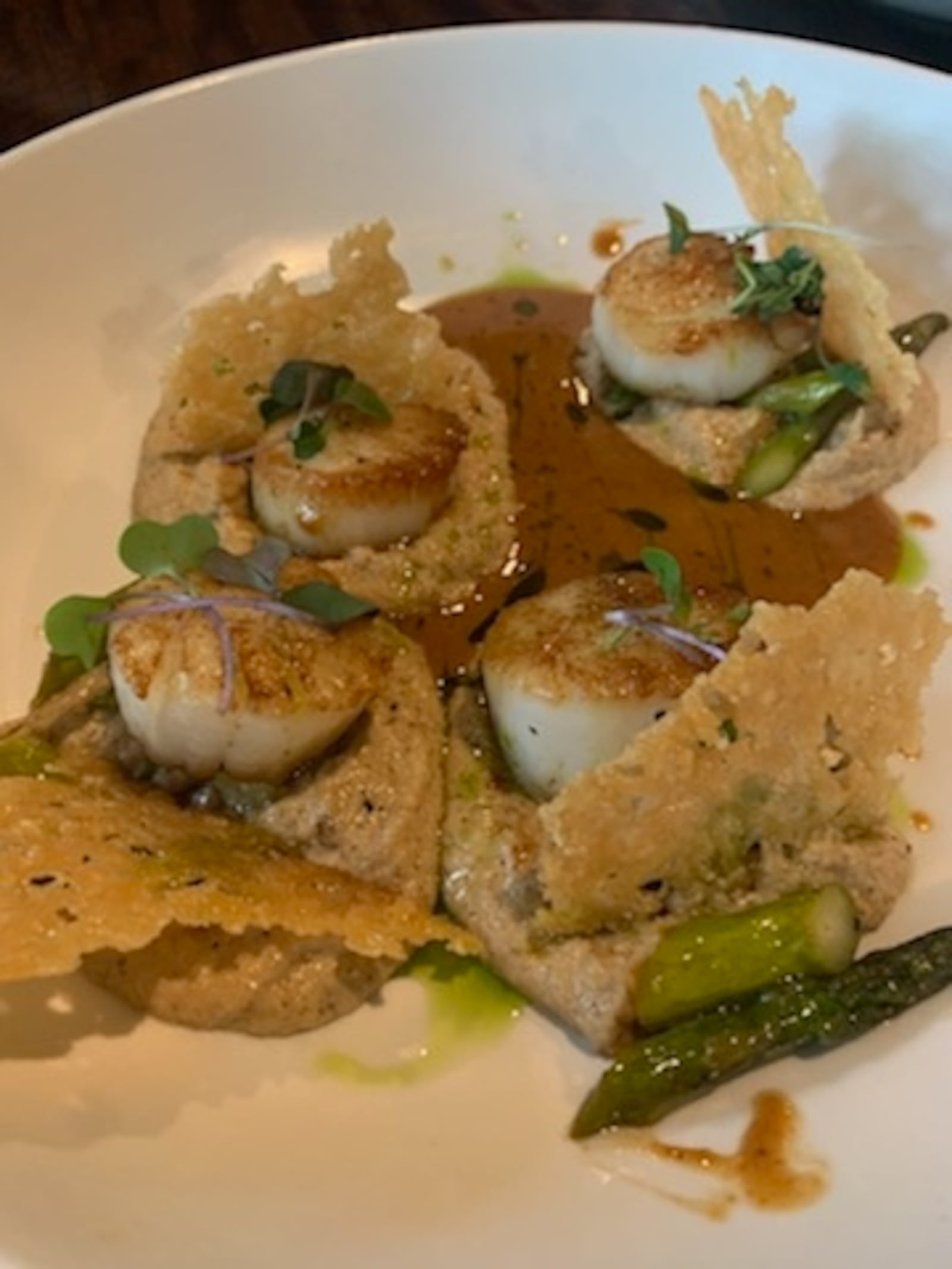 Watermark's pan-seared scallop dish  features fresh sea scallops, sun-dried tomato beurre blanc, accompanied by a creamy brown butter cauliflower mousse, asparagus, garnished with a parmesan crisp. CONTRIBUTED