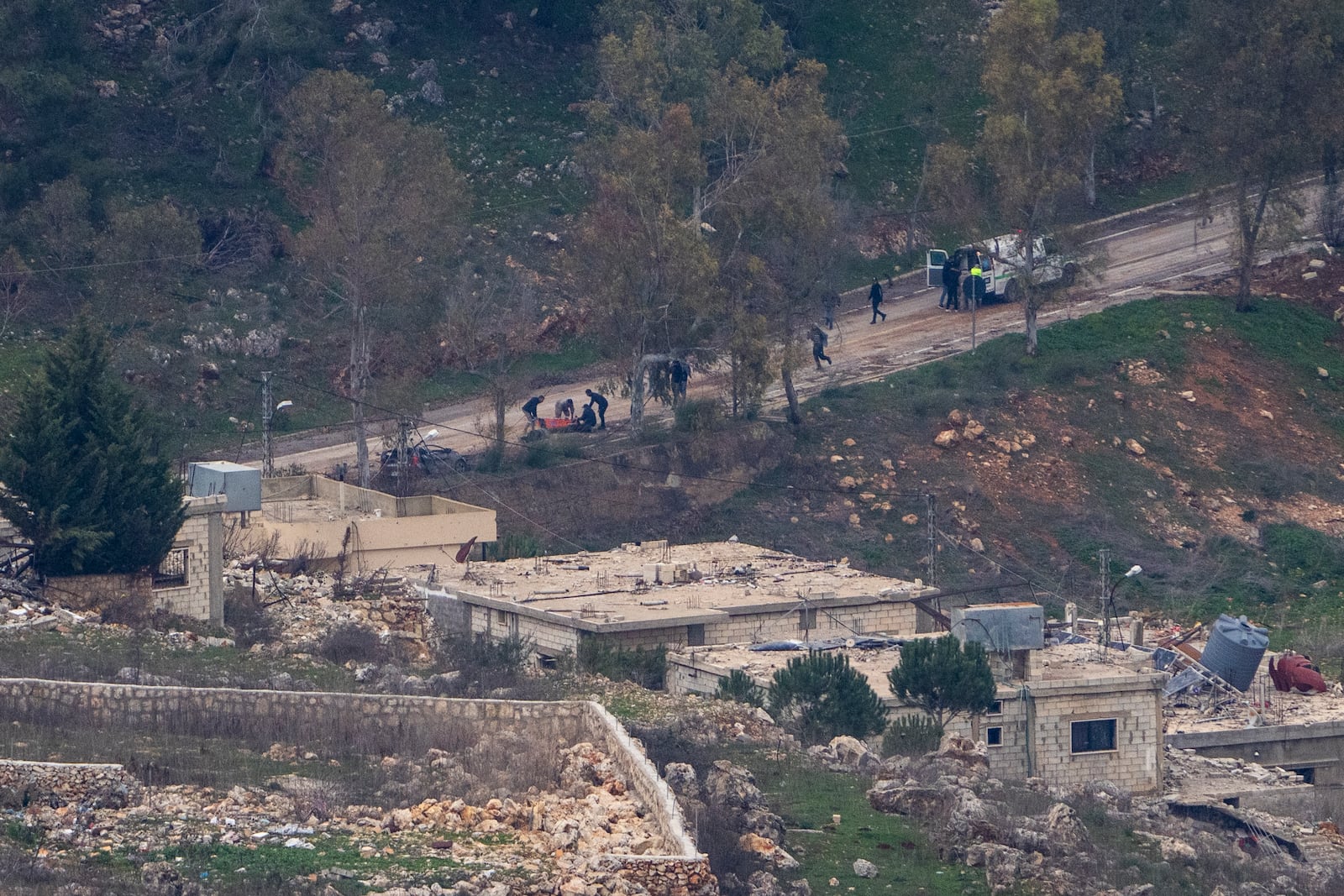 Lebanese emergency services evacuate people wounded by gunshots in a southern Lebanese village, where Israeli soldiers continue to operate despite the ceasefire, as seen from northern Israel Sunday, Jan. 26, 2025. (AP Photo/Ariel Schalit)