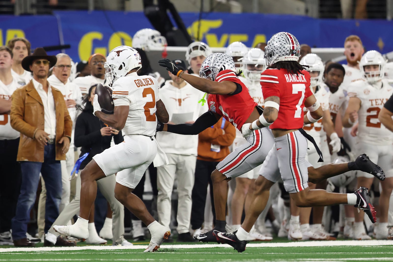 Actor Matthew McConaughey, left, watches as Texas wide receiver Matthew Golden (2) runs toward the sideline against Ohio State cornerback Davison Igbinosun, middle, and cornerback Jordan Hancock (7) during the first half of the Cotton Bowl College Football Playoff semifinal game, Friday, Jan. 10, 2025, in Arlington, Texas. (AP Photo/Gareth Patterson)