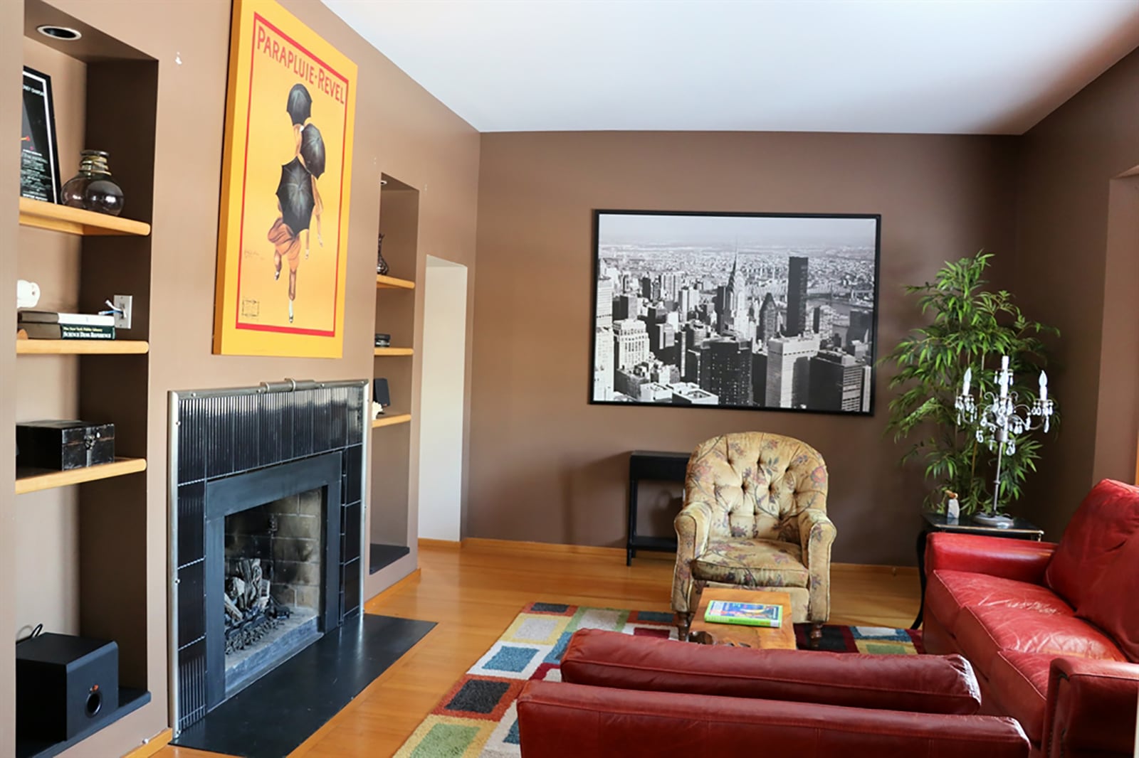 The living room’s centerpiece is a fireplace with black-tile surround and flanked by lighted artwork nooks. Opposite the fireplace is the triangular bay window. CONTRIBUTED PHOTO BY KATHY TYLER