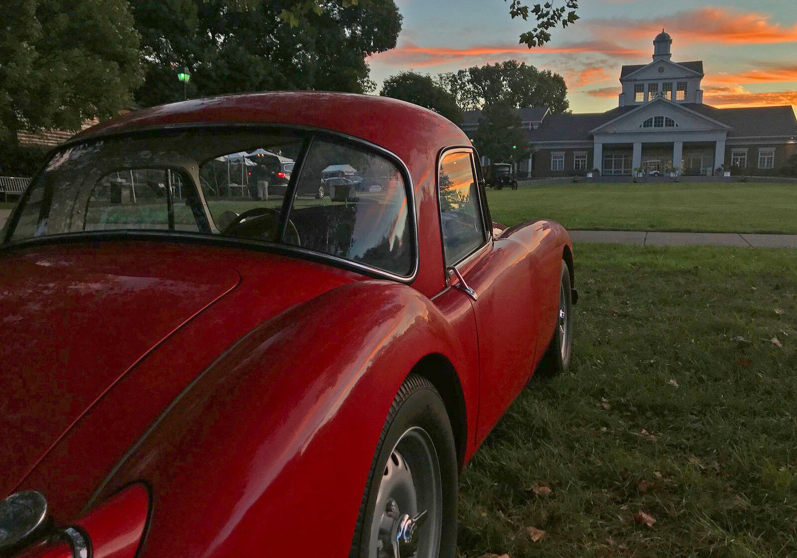 Rick Grant's MGA Twin Cam coupe is on the showfield at the Dayton Concours d'Elegance at Carillon Park as the sun rises over the park's main building. Contributed photo by Skip Peterson