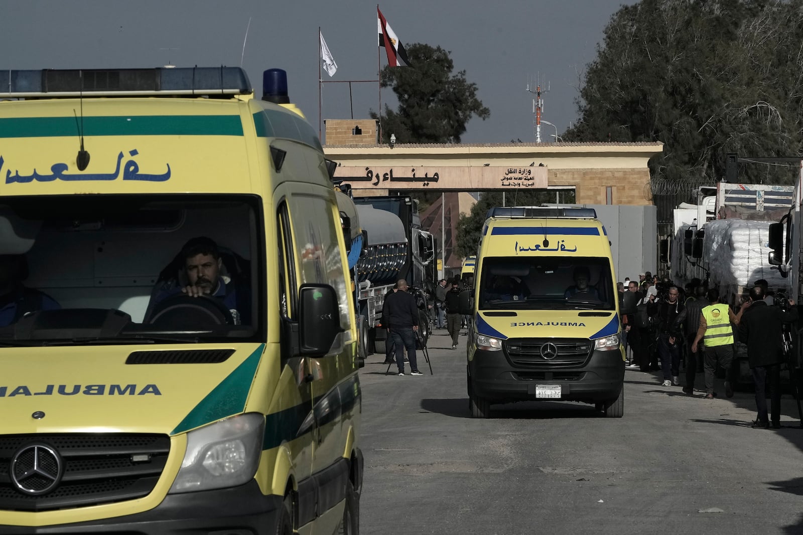 Ambulances pass in front of the Rafah border crossing between Egypt and the Gaza Strip , Sunday, Jan. 19, 2025. (AP Photo/Amr Nabil)