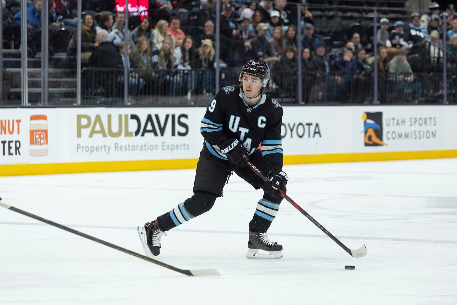 Utah Hockey Club center Clayton Keller (9) moves the puck on the ice against the Columbus Blue Jackets during the first period of an NHL hockey game Friday, Jan. 31, 2025, in Salt Lake City. (AP Photo/Melissa Majchrzak)