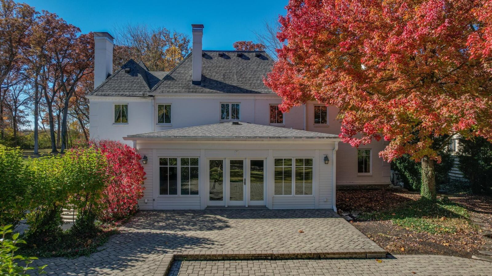 The rear of the home features a large paver patio and extensive landscaping.