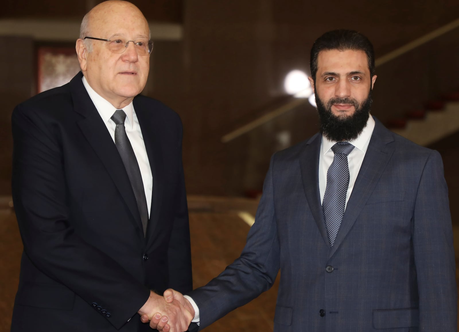 In this photo released by Lebanon's Prime Minister's office, Syria's de facto leader Ahmad al-Sharaa, formerly known as Abu Mohammed al-Golani, right, meets with Lebanon's caretaker Prime Minister Najib Mikati in Damascus, Syria, Saturday Jan. 11, 2025. (LEBANON PRIME MINISTER'S OFFICE via AP)