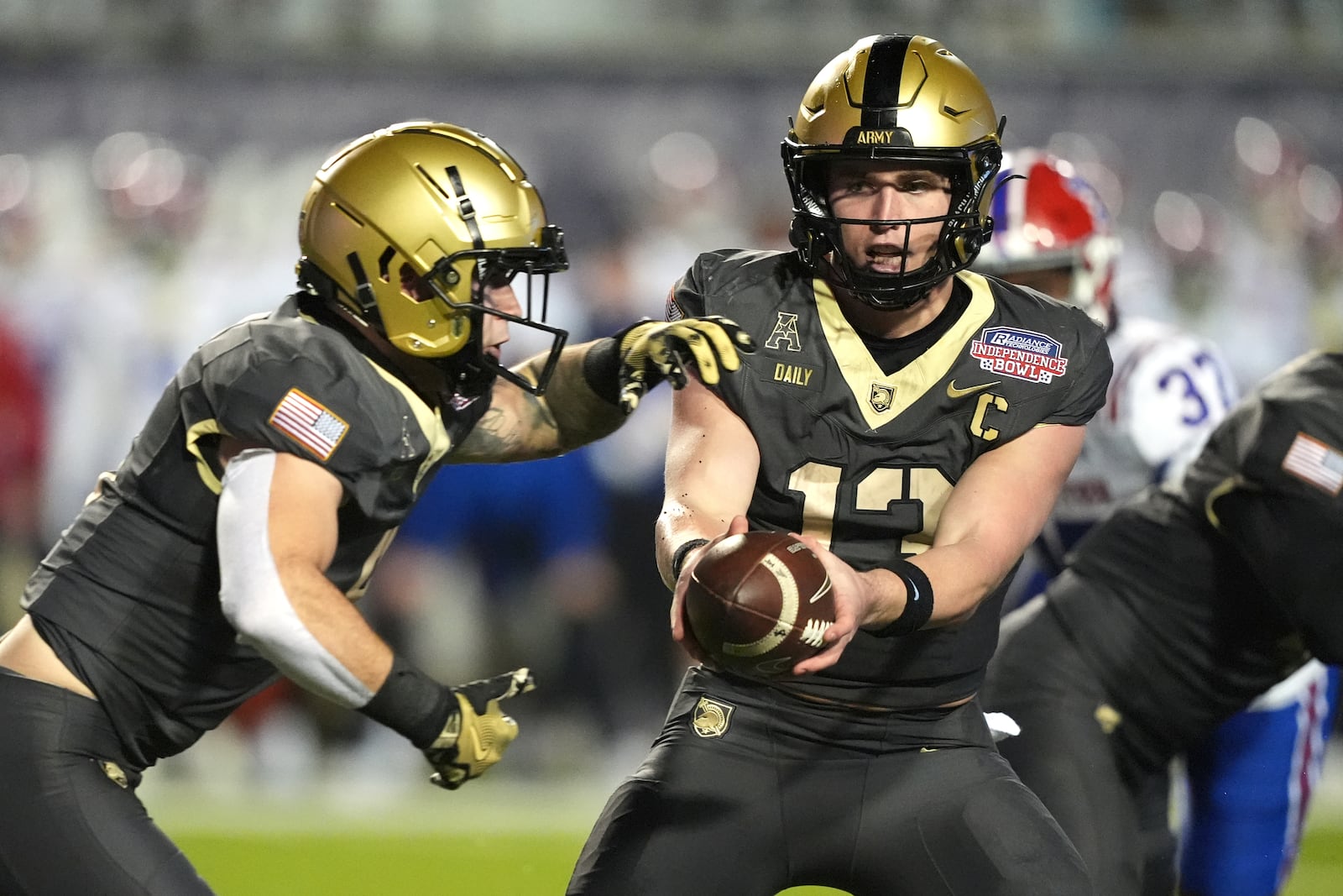 Army quarterback Bryson Daily (13) hands off to running back Hayden Reed, left, during the first half of the Independence Bowl NCAA college football game against Louisiana Tech, Saturday, Dec. 28, 2024, in Shreveport, La. (AP Photo/Rogelio V. Solis)