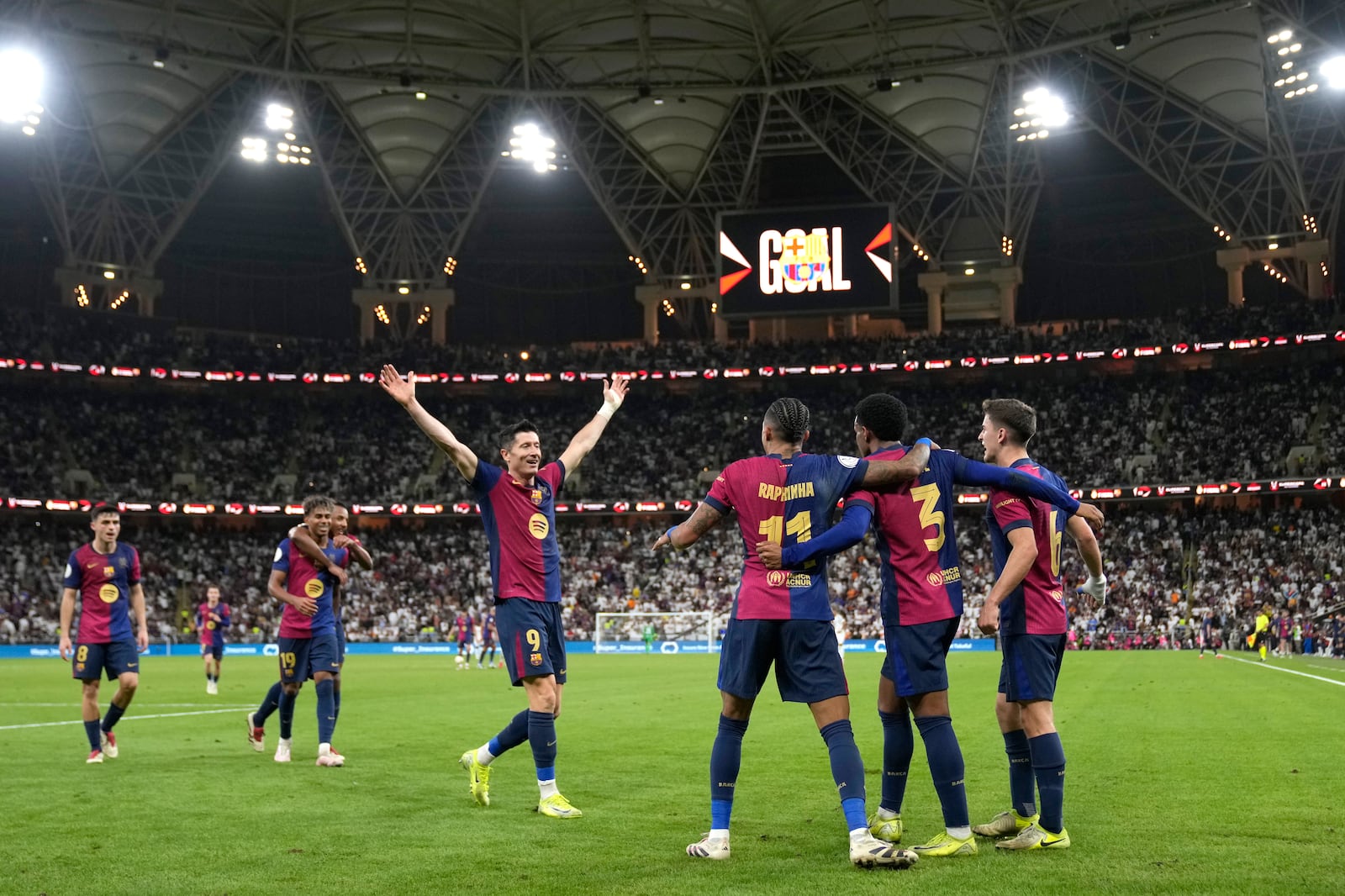 Barcelona players celebrate after Barcelona's Alejandro Balde, second right, scored his side's fourth goal during the Spain Super Cup final soccer match between Real Madrid and Barcelona at King Abdullah Stadium in Jeddah, Saudi Arabia, Sunday, Jan. 12, 2025. (AP Photo/Altaf Qadri)