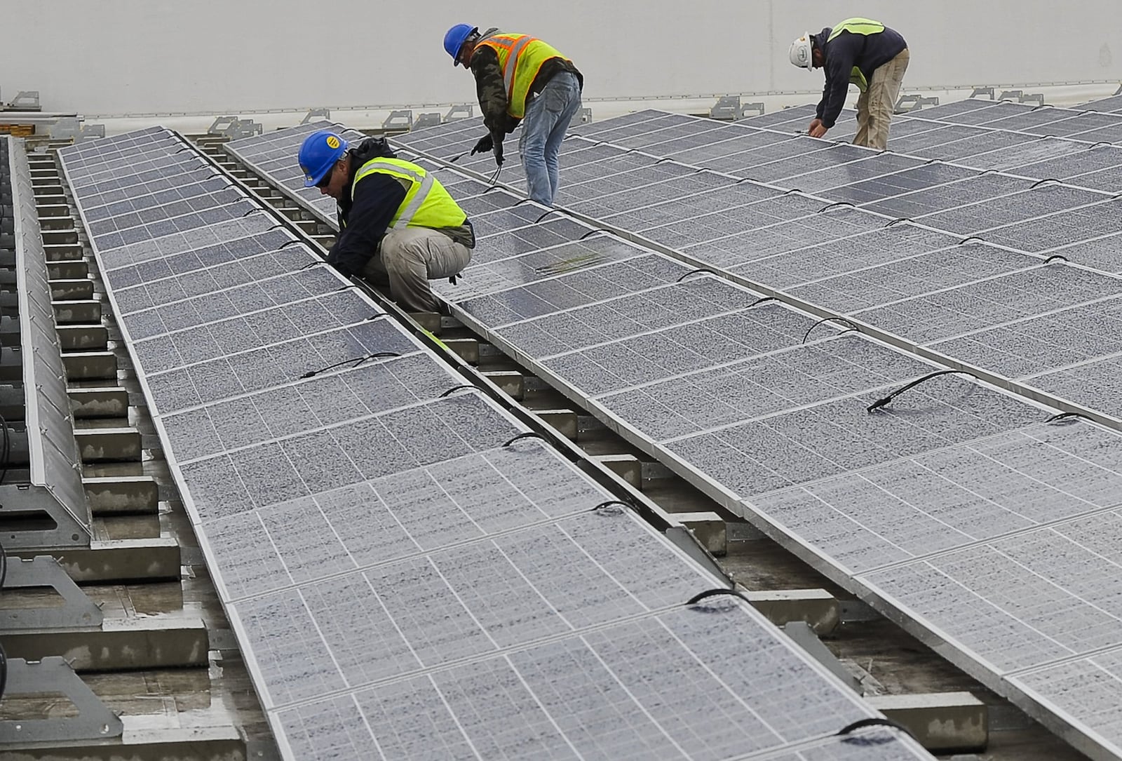 Workers maintain the 6,200 solar panels on the roof of the Assurant Group buildings in Springfield Wednesday. The $7 million project to install solar panels is planned to generate more then 1.9 million kilowatt hours of solar power annually. Staff photo by Bill Lackey