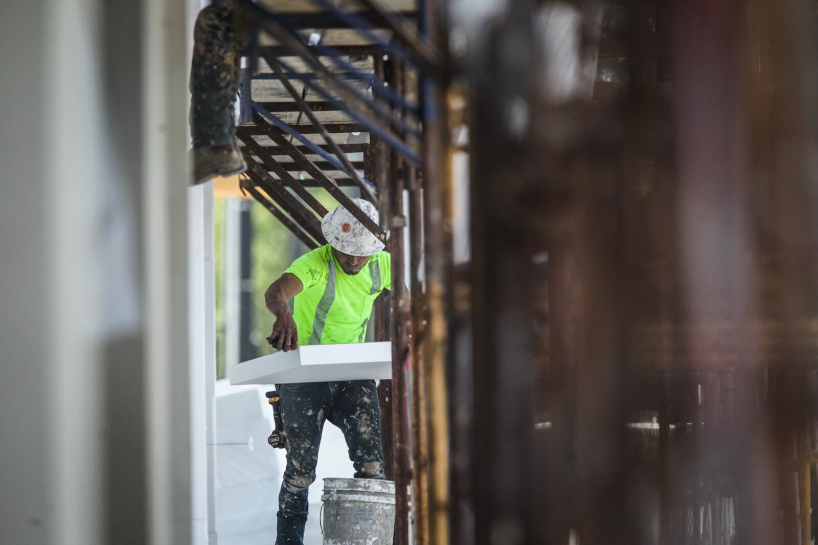 A construction worker applies insulation on a  large building under construction on Brown St. Wednesday June 16, 2021.