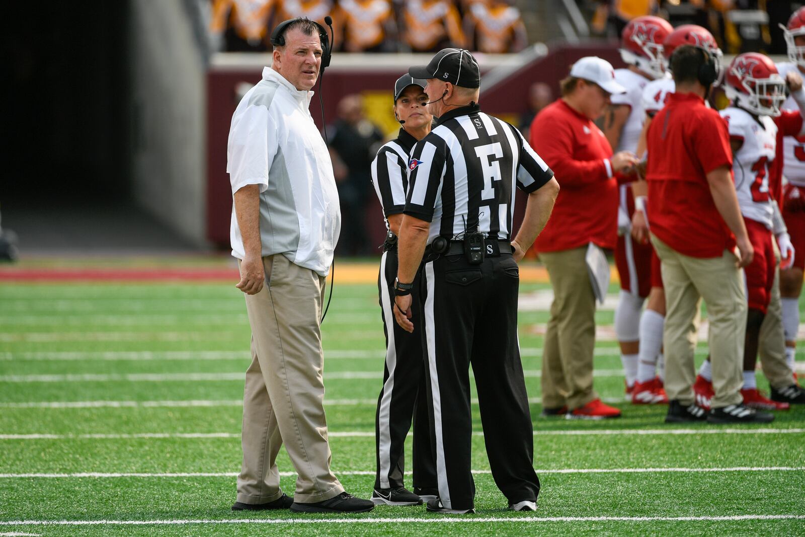 Miami-Ohio head coach Chuck Martin, left, talks with the game officials during a break in the first half of an NCAA college football game against Minnesota Saturday, Sept. 11, 2021, in Minneapolis. Minnesota won 31-26. (AP Photo/Craig Lassig)