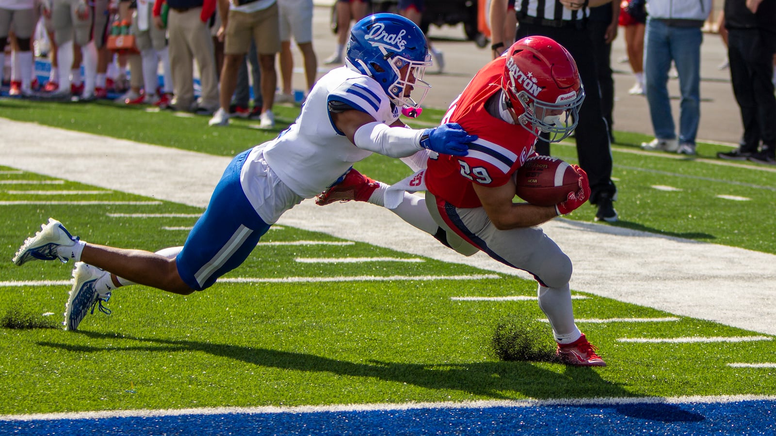 Dayton's Jake Chisholm scores a first-quarter touchdown Saturday against Drake's Luke Bailey at Welcome Stadium. CONTRIBUTED/Jeff Gilbert