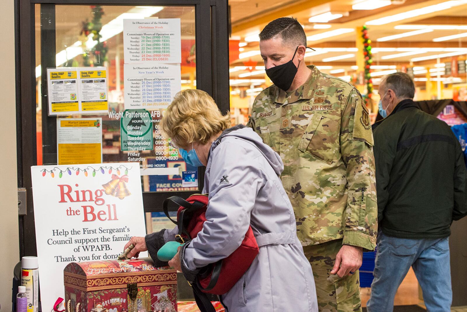 Chief Master Sgt. Jason Shaffer, 88th Air Base Wing command chief, thanks a commissary shopper as she donates to the First Sergeants Council’s “Ring the Bell” campaign Dec. 10 at Wright-Patterson Air Force Base. U.S. AIR FORCE PHOTO/JAIMA FOGG