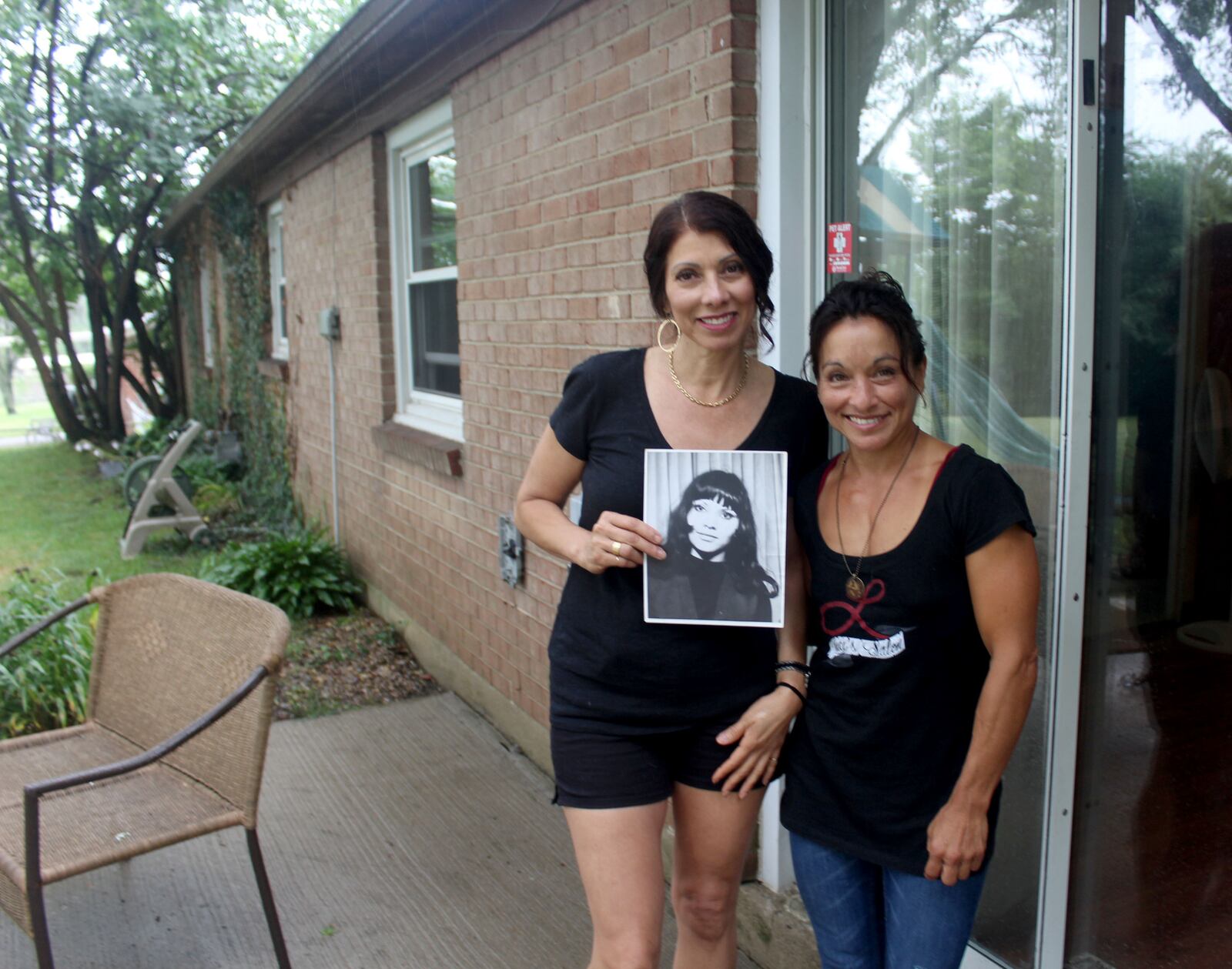 Adopted at birth, Lucianna Seed recently met family members she never knew she had including Centerville's Raquel Rivera-Hill.  The sisters hold a photo of their mom Yadira Rivera.