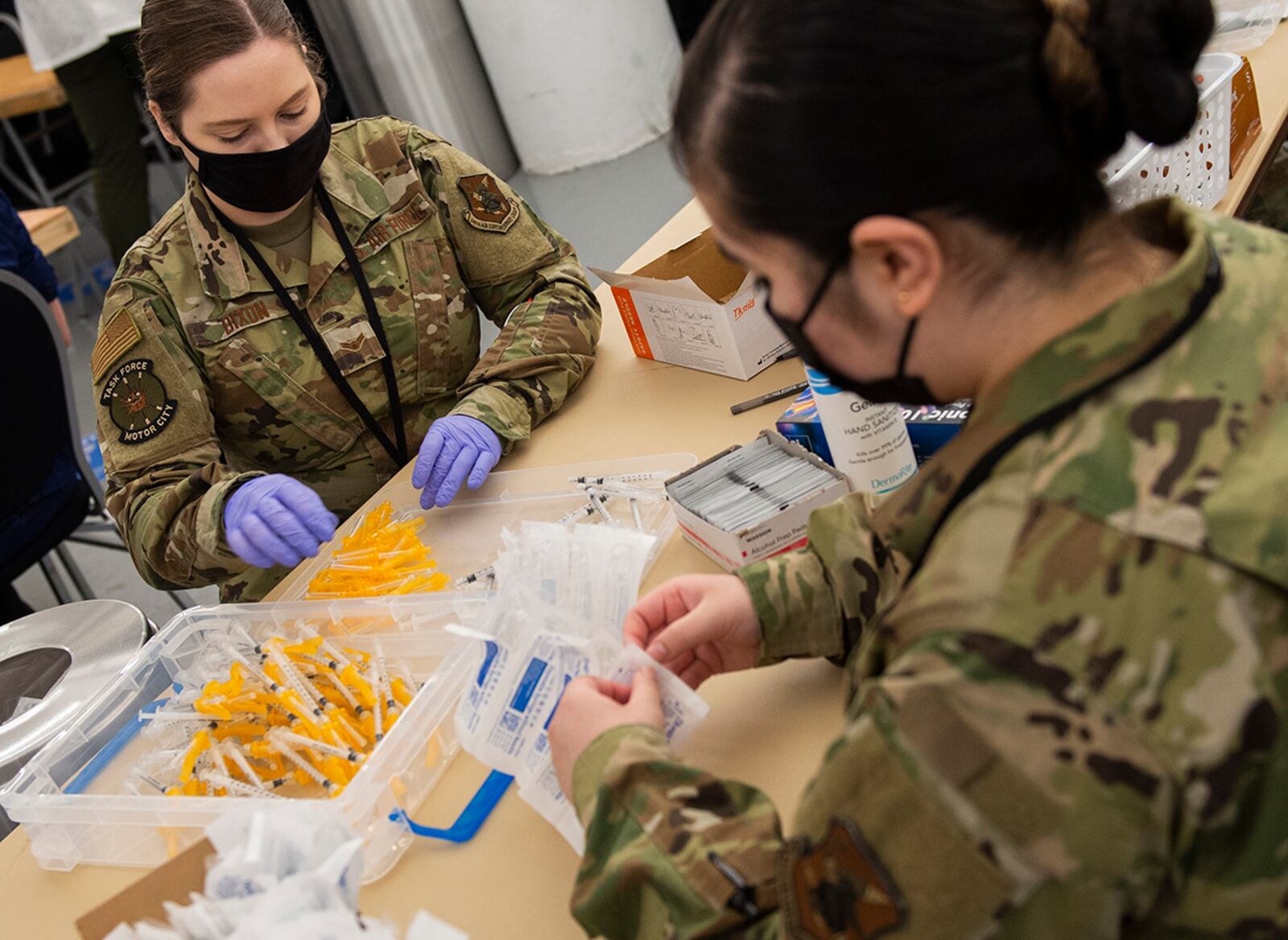 Airmen assemble syringes for use in distribution of the COVID-19 vaccine inside the pharmacy area of community vaccination center at Ford Field in Detroit on May 3. U.S. AIR FORCE PHOTO/WESLEY FARNSWORTH