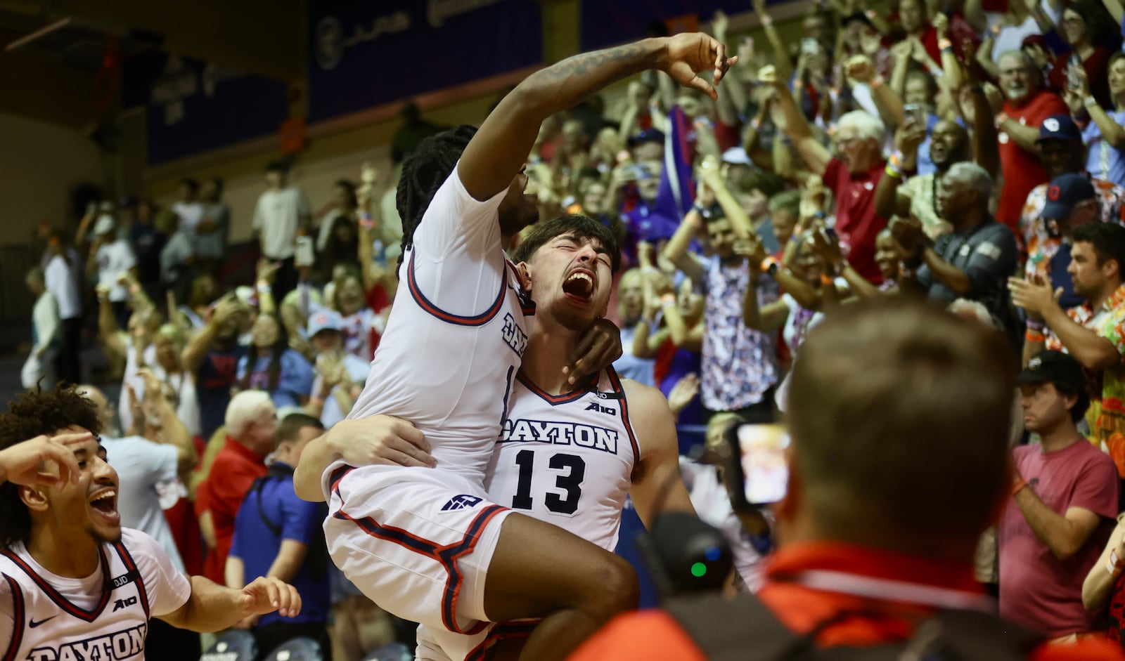 Dayton's Isaac Jack carries Malachi Smith off the court after a victory against Connecticut in the Maui Invitational on Wednesday, Nov. 27, 2024, at the Lahaina Civic Center. David Jablonski/Staff