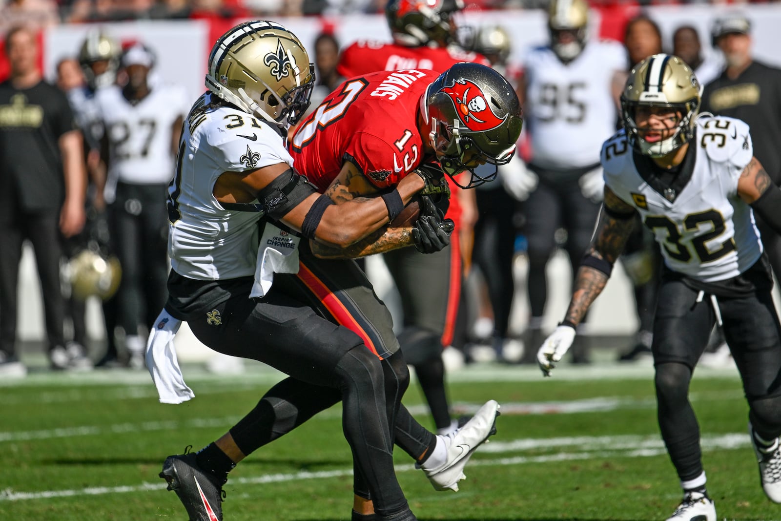 Tampa Bay Buccaneers wide receiver Mike Evans (13) is brought down by New Orleans Saints safety Jordan Howden (31) during the first half of an NFL football game Sunday, Jan. 5, 2025, in Tampa, Fla. (AP Photo/Jason Behnken)