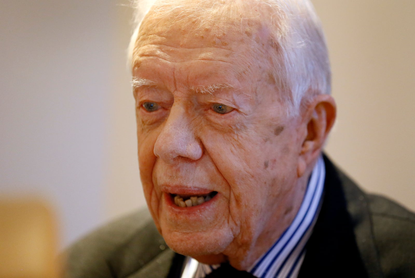 FILE - Former US President Jimmy Carter listens during a video interview with the Associated Press via a laptop at a hotel in London, Tuesday, Feb. 2, 2016. (AP Photo/Kirsty Wigglesworth, File)