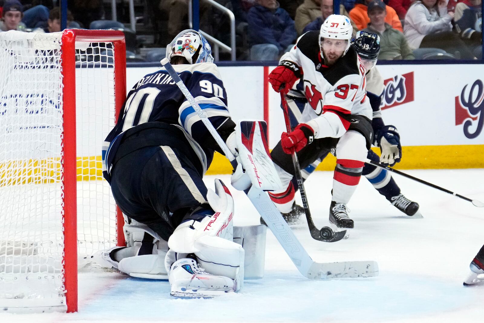 New Jersey Devils center Justin Dowling (37) shoots against Columbus Blue Jackets goaltender Elvis Merzlikins (90) in the third period of an NHL hockey game Thursday, Dec. 19, 2024, in Columbus, Ohio. (AP Photo/Sue Ogrocki)