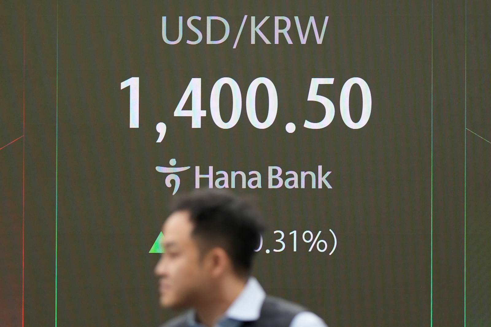 A currency trader walks by the screens showing the foreign exchange rate between U.S. dollar and South Korean won at a foreign exchange dealing room in Seoul, South Korea, Thursday, Nov. 7, 2024. (AP Photo/Lee Jin-man)