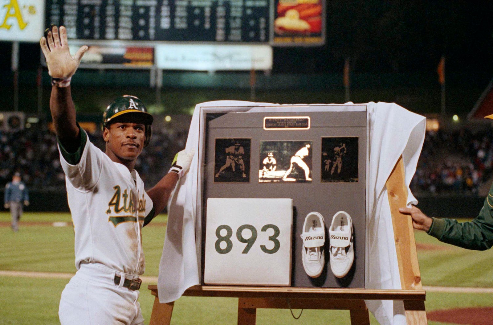 FILE - Rickey Henderson waves to the crowd during a presentation after he stole third base against the Toronto Blue Jays in the seventh inning to break Ty Cobb's career stolen base record, at Oakland Coliseum in Oakland, Calif., May 30, 1990. (AP Photo/Paul Sakuma, File)