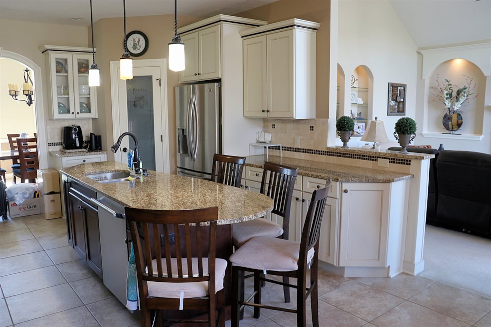 In the kitchen, antique white cabinetry with accent roping fills two walls, and granite counters provide plenty of preparation space.