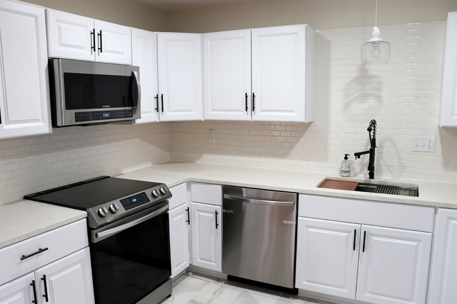 Tucked off the dining room, the renovated kitchen has granite countertops on new white cabinets. Subway tile adds texture to the wall space and acts as a backsplash above the large sink and faucet. CONTRIBUTED PHOTO BY KATHY TYLER