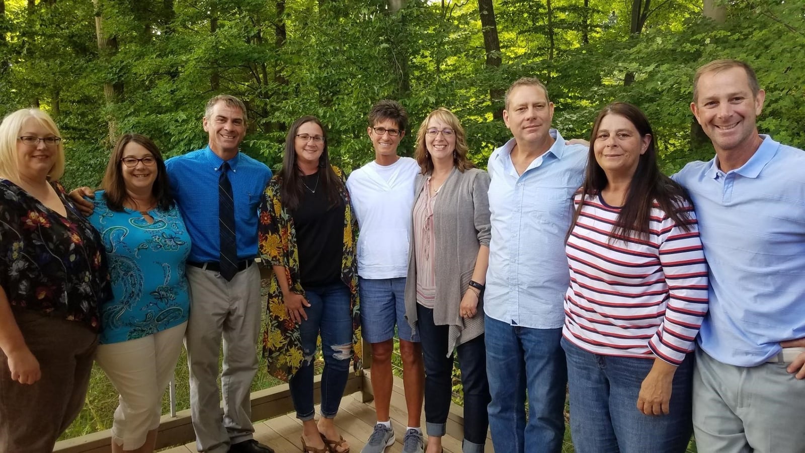 Chris Hart (in center, white shirt) with eight new brothers and sisters — the eight children of Don Roth, her birth dad who lives in Norwalk. They all met this past September in Norwalk. CONTRIBUTED