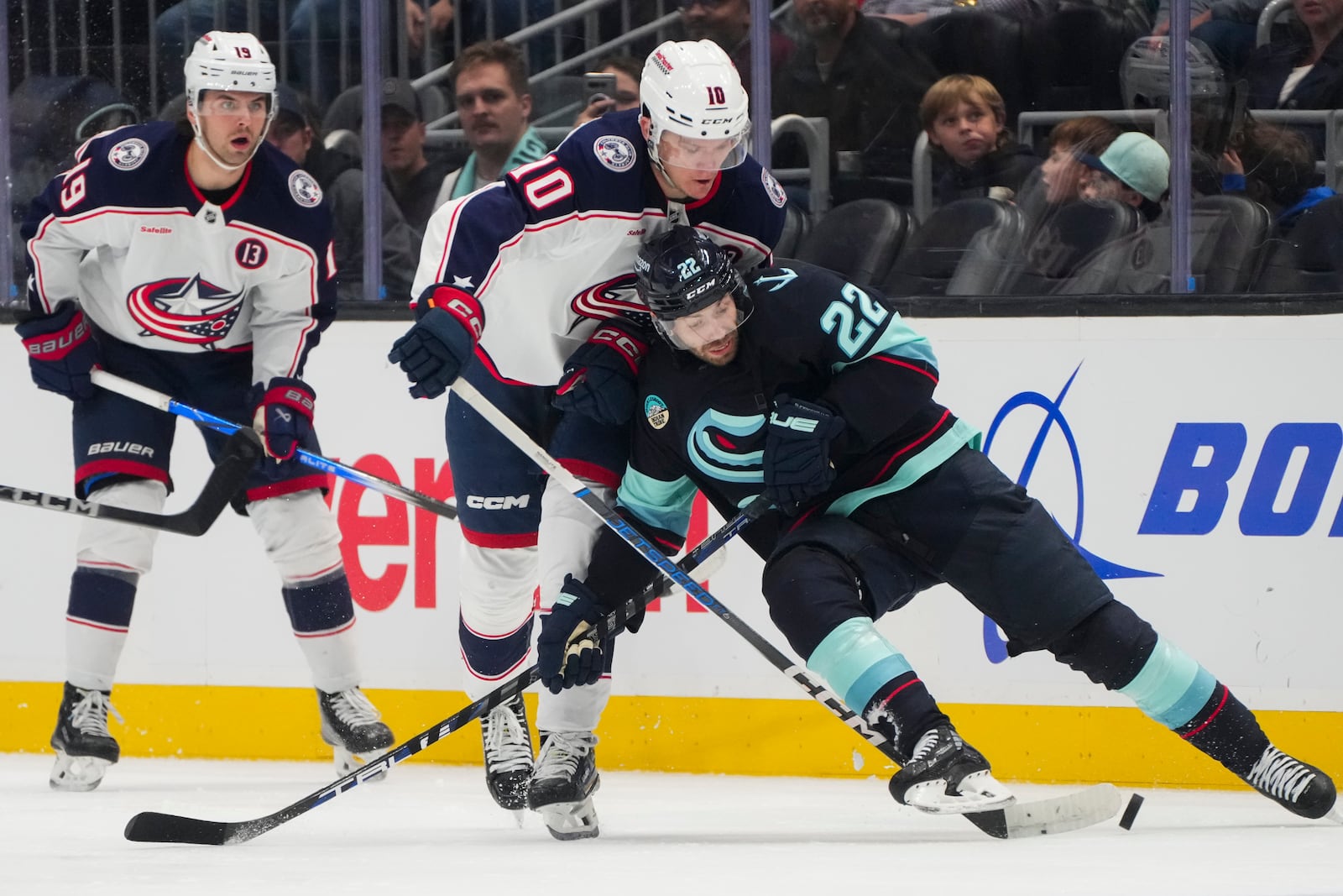 Seattle Kraken right wing Oliver Bjorkstrand (22) loses his footing against Columbus Blue Jackets left wing Dmitri Voronkov (10) while vying for the puck during the second period of an NHL hockey game Tuesday, Nov. 12, 2024, in Seattle. (AP Photo/Lindsey Wasson)