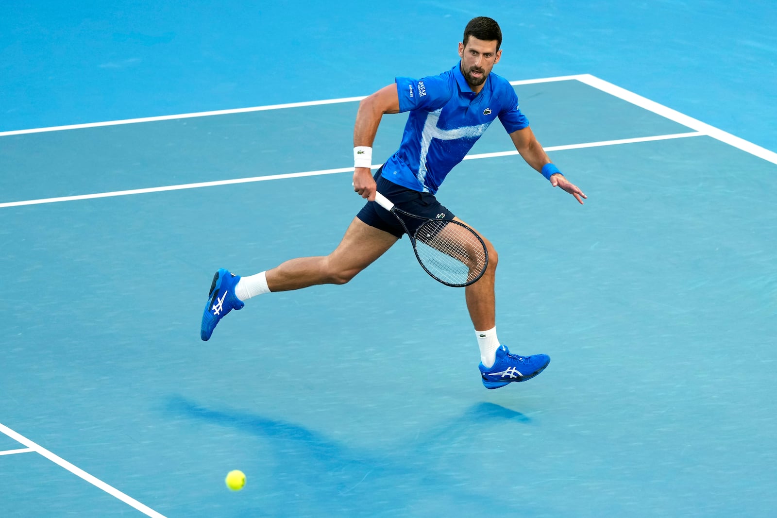 Novak Djokovic of Serbia plays a backhand return to Nishesh Basavareddy of the U.S. during their first round match at the Australian Open tennis championship in Melbourne, Australia, Monday, Jan. 13, 2025. (AP Photo/Asanka Brendon Ratnayake)