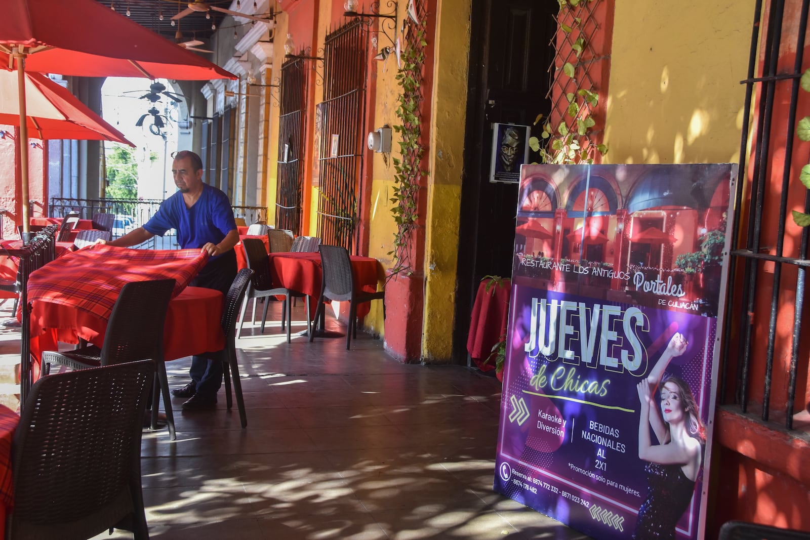 A waiter arranges a table outside the restaurant The Old Portales of Culiacan where a sign advertises two-for-one prices on drinks for women on Thursdays, in Culiacan, Sinaloa state, Mexico, Monday, Oct. 14, 2024. (AP Photo)