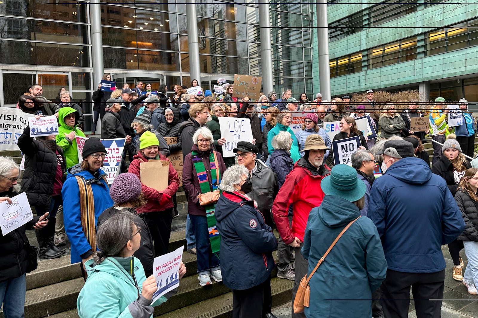 People gather outside the U.S. District Court after a federal judge blocked President Donald Trump's effort to halt the nation's refugee admissions system Tuesday, Feb. 25, 2025, in Seattle. (AP Photo/Eugene Johnson)