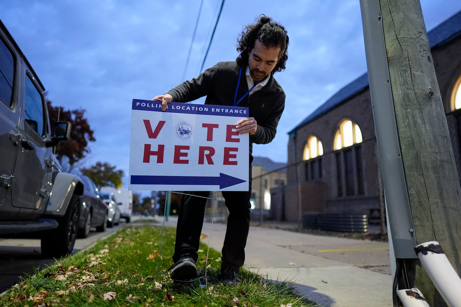 Election day worker Sean Vander Waal prepares to open a polling place,Tuesday, Nov. 5, 2024, in Dearborn, Mich. (AP Photo/Charlie Neibergall)