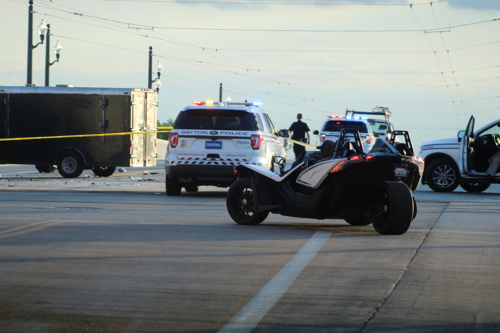 A three-wheeled vehicle makes a U-turn as Dayton police block traffic following a crash on the Third Street bridge. CORNELIUS FROLIK / STAFF