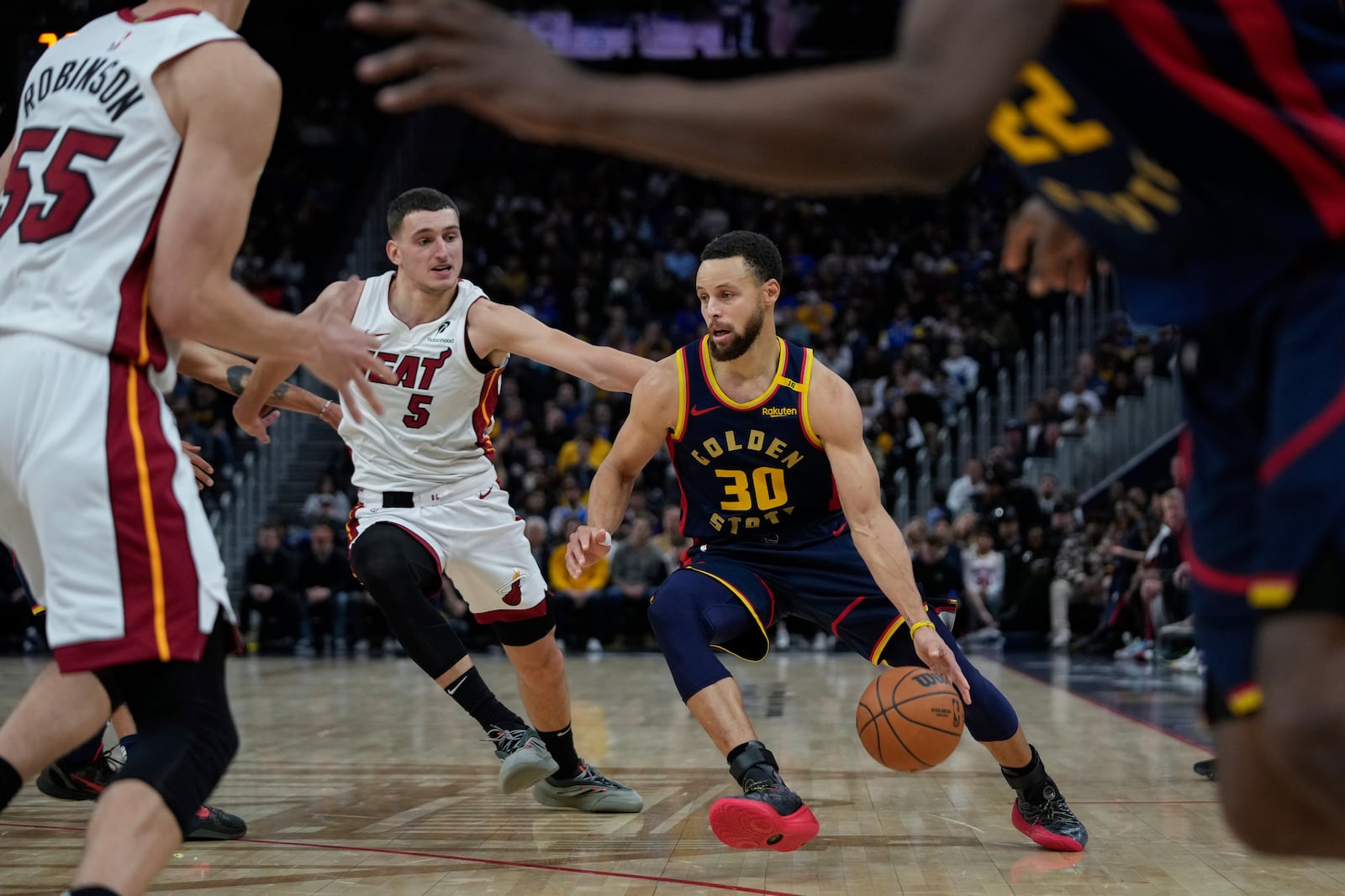 Golden State Warriors guard Stephen Curry (30) moves the ball while defended by Miami Heat forward Nikola Jovic (5) during the second half of an NBA basketball game Tuesday, Jan. 7, 2025, in San Francisco. (AP Photo/Godofredo A. Vásquez)