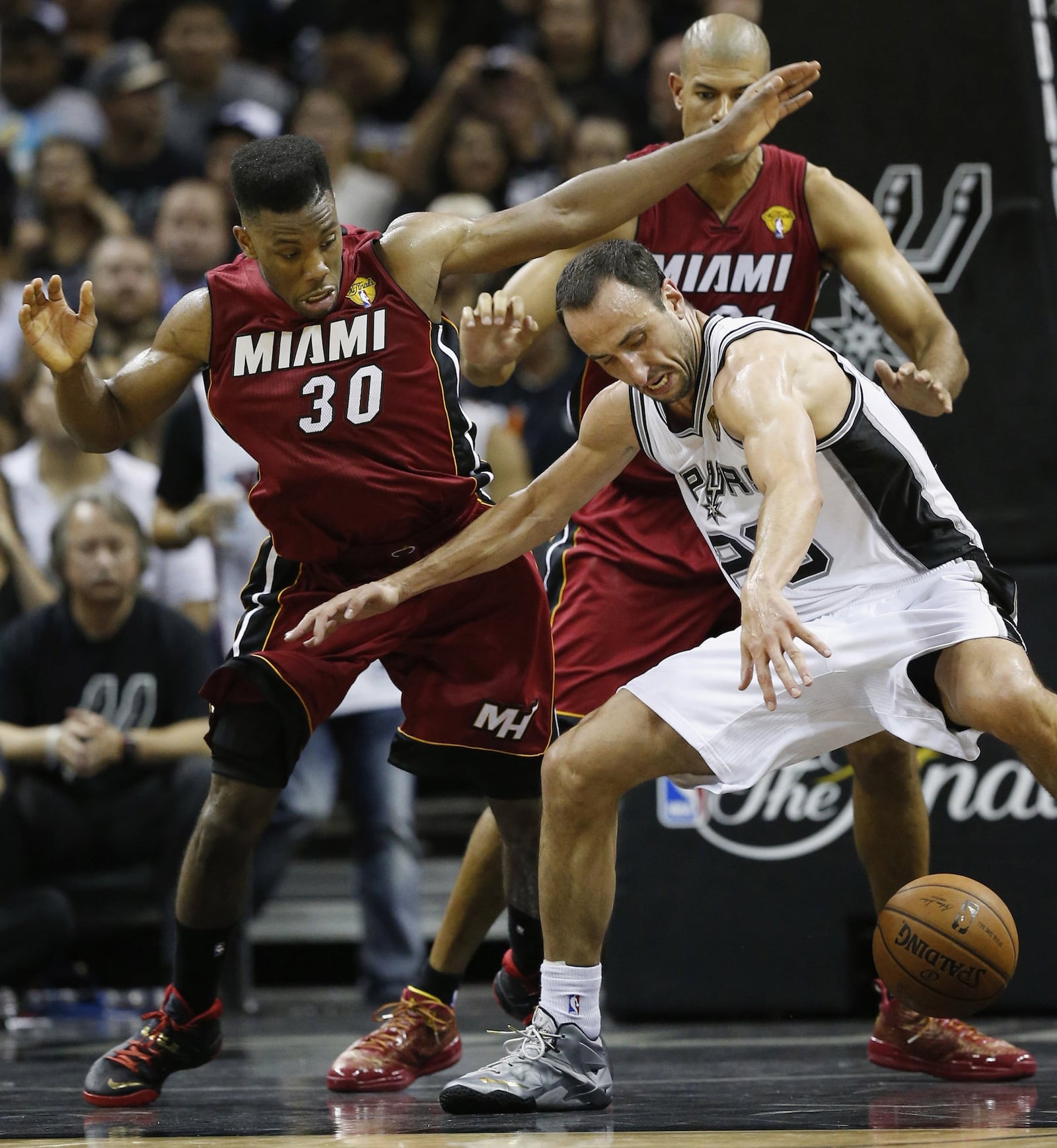 The San Antonio Spurs' Manu Ginobili, right, chases a loose ball against the Miami Heat's Norris Cole, left, and Shane Battier during the second half in Game 1 of the NBA Finals on Thursday, June 5, 2014, at the AT&T Center in San Antonio. The Spurs won, 110-95. (Al Diaz/Miami Herald/MCT)