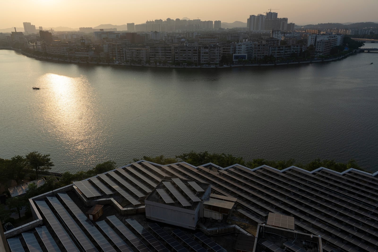 Solar panels on a roof are seen near the sunrise over Jiangmen in southern China's Guangdong province on Friday, Oct. 11, 2024. (AP Photo/Ng Han Guan)