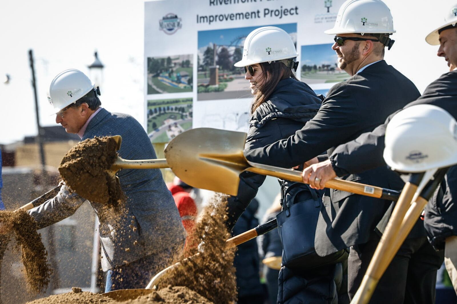 Members of the Miamisburg Community Foundation throw dirt during a groundbreaking ceremony for the Riverfront Park Improvement Project Tuesday, April 18, 2023. The upgraded park will feature a permanent amphitheater, a nature-based playground and  inclusive play spaces. JIM NOELKER/STAFF