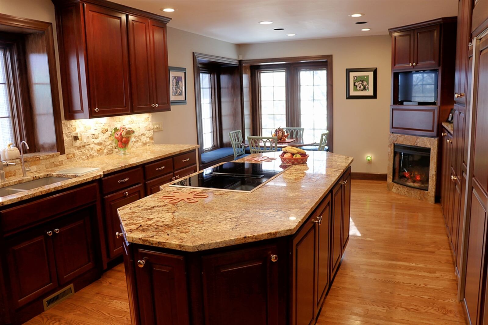 The eat-in kitchen has a galley design with a long island within the kitchen area. It also features corner window seats for a breakfast nook. 