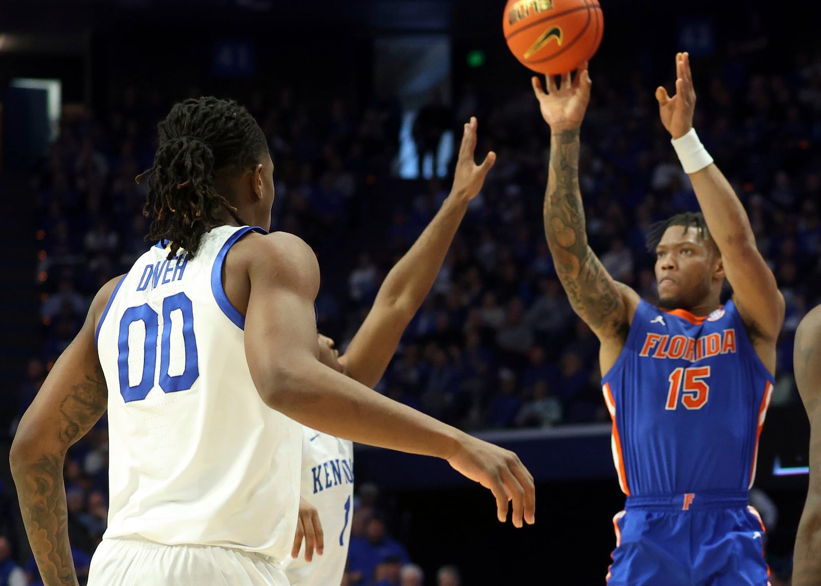 Florida's Alijah Martin (15) shoots over the defense of Kentucky's Lamont Butler, center, and Otega Oweh (00) during the second half of an NCAA college basketball game in Lexington, Ky., Saturday, Jan. 4, 2025. (AP Photo/James Crisp)